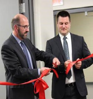 Picture of Daryl Schatz and Francis Poulin cutting the symbolic ribbon at the Centre Info-Justice Saskatchewan opening.